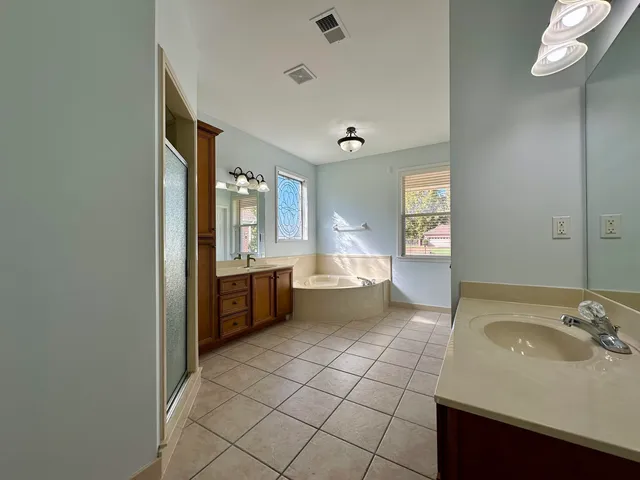 a large bathroom with a sink a mirror and a bathtub