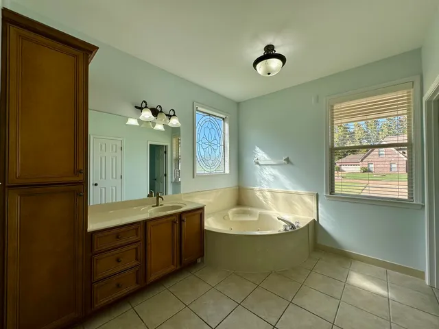 a bathroom with a tub sink and mirror