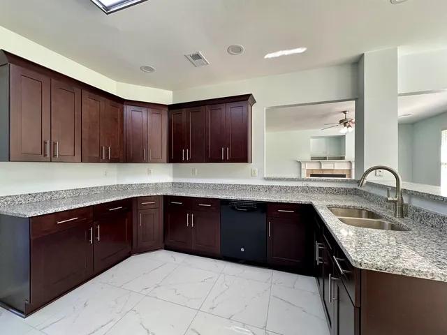 a kitchen with granite countertop a sink and cabinets