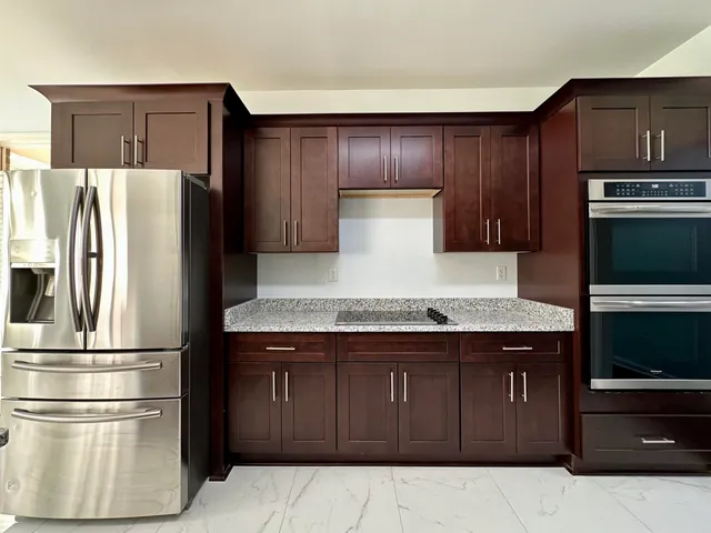a kitchen with stainless steel appliances granite countertop a refrigerator and a stove
