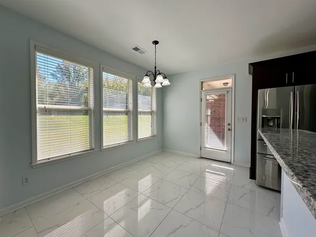 a view of an empty room with a kitchen