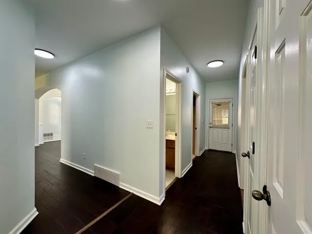 an empty room with wooden floor and mirror