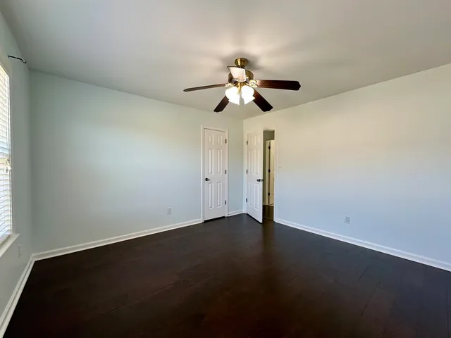 an empty room with a window and a fan