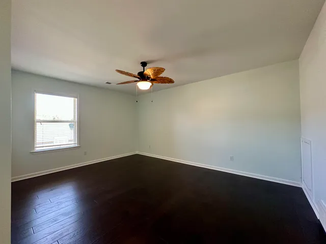 a view of a livingroom with wooden floor and a large window