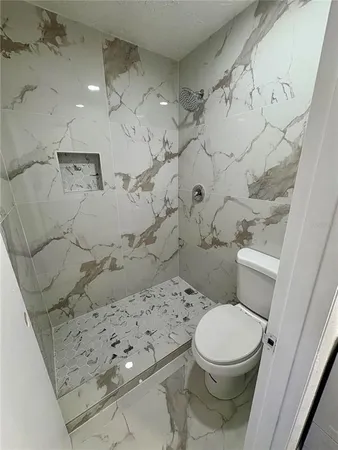 a white toilet sitting next to a bathroom sink