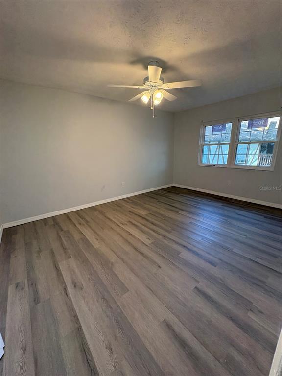 5401 Hansel Avenue, Unit 2 Orlando, FL 32809 - Photo 14 of 25 an empty room with wooden floor chandelier fan and windows