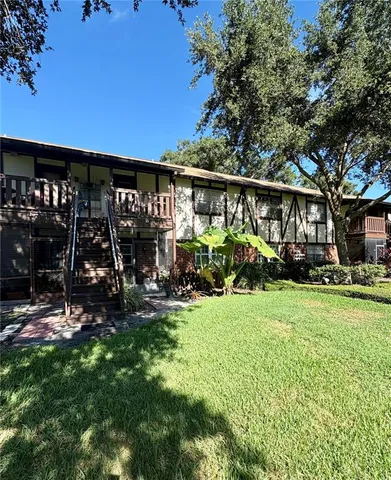 a view of a house with yard and sitting area