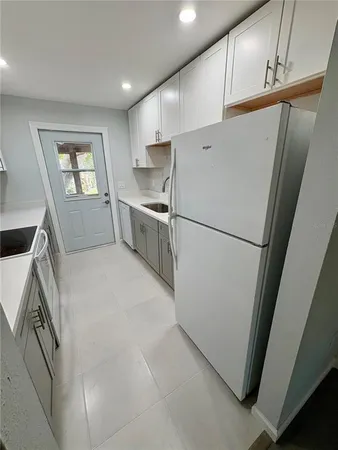 a kitchen with white cabinets and white appliances
