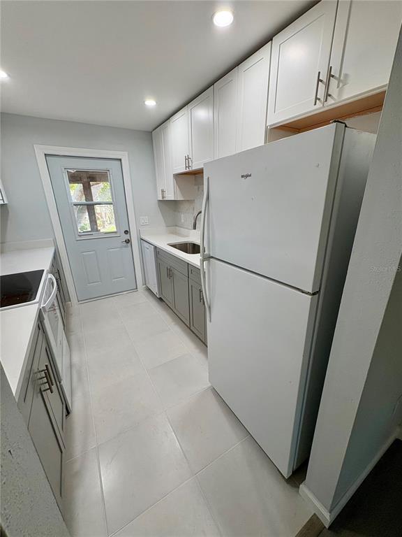 5401 Hansel Avenue, Unit 2 Orlando, FL 32809 - Photo 4 of 25 a kitchen with white cabinets and white appliances