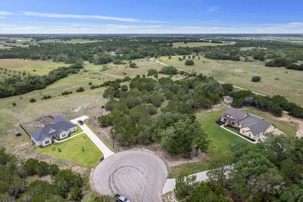 an aerial view of ocean and residential houses with outdoor space