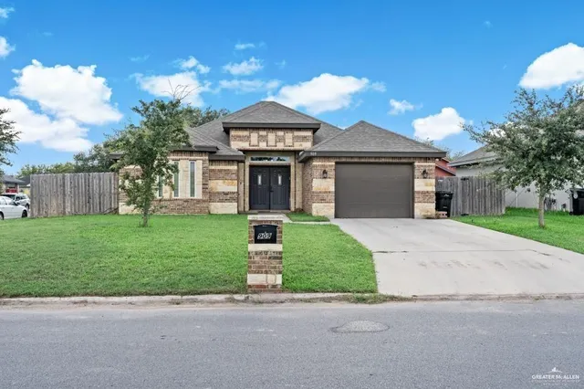 a front view of a house with a garden and yard