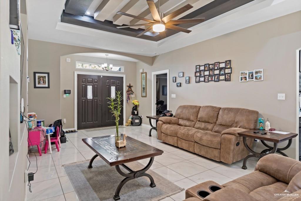 909 Emerald Avenue Weslaco, TX 78599 - Photo 2 of 5 a living room with furniture a chandelier and a dining table