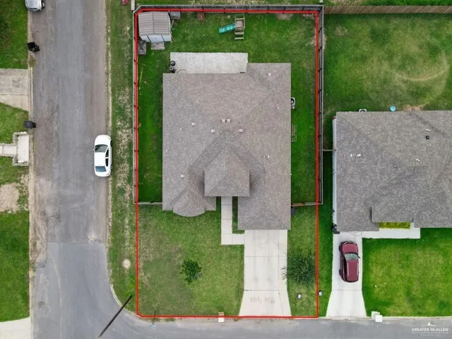 an aerial view of a house with garden space and street view