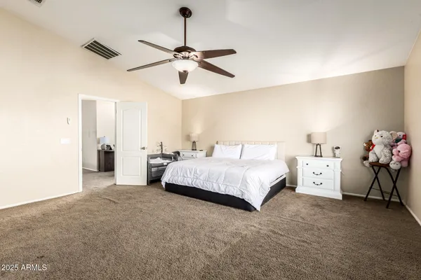a bedroom with a bed and a chandelier fan