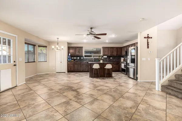 a view of a electric appliances in kitchen and empty room with wooden floor