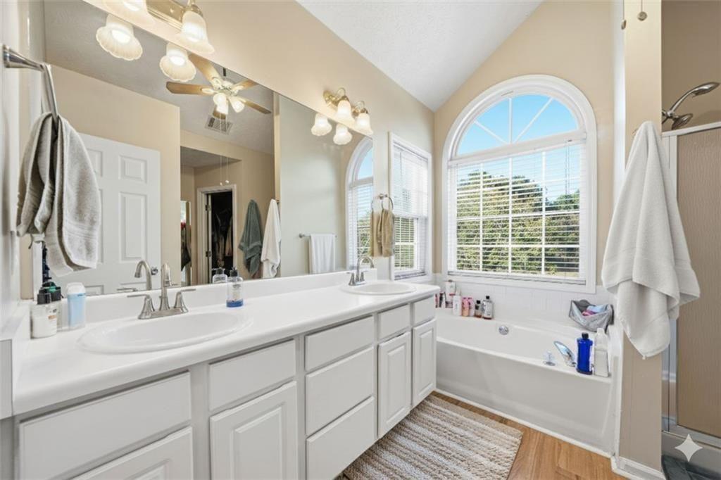 147 Midland Drive Stockbridge, GA 30281 - Photo 14 of 30 a bathroom with a tub a sink double vanity and a large mirror