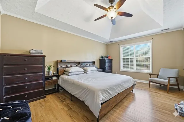 a bedroom with a bed and wooden floor