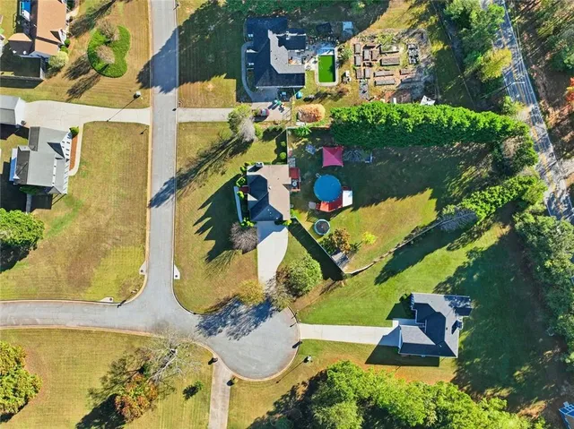 an aerial view of a residential houses with yard