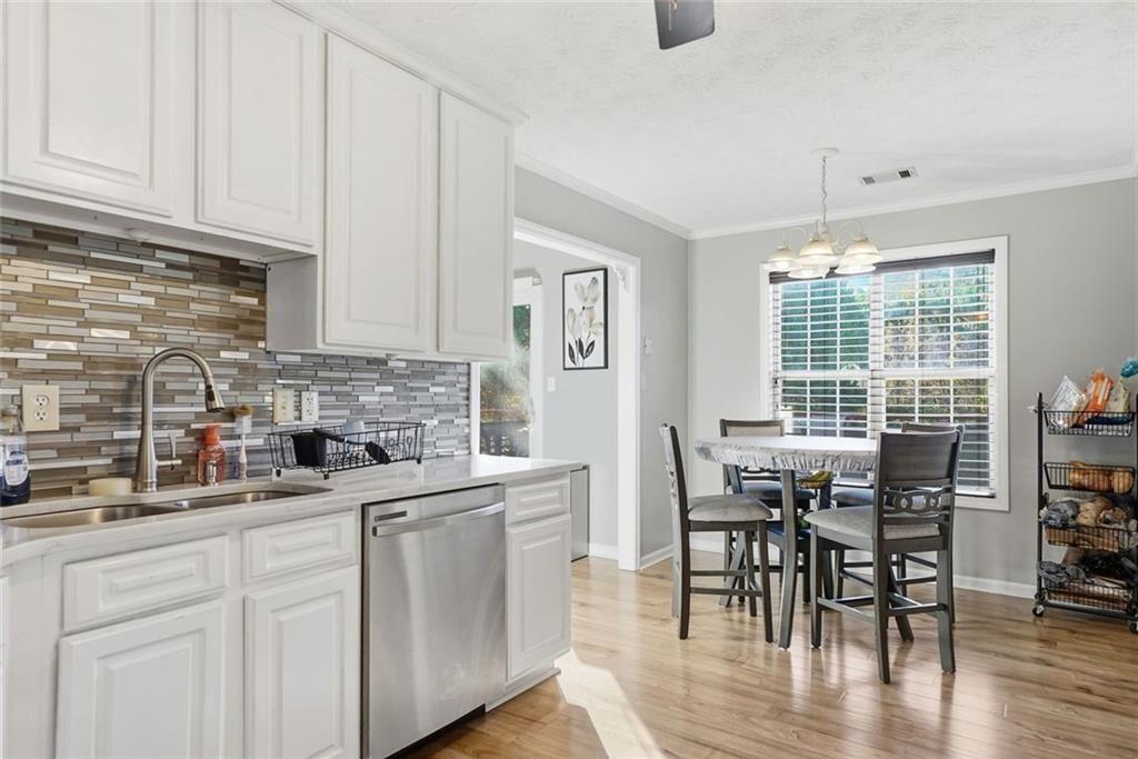147 Midland Drive Stockbridge, GA 30281 - Photo 30 of 30 a kitchen with stainless steel appliances granite countertop a stove top oven a sink a dining table and chairs with wooden floor