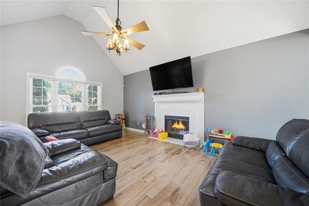 147 Midland Drive Stockbridge, GA 30281 - Photo 3 of 30 a living room with furniture a fireplace and a flat screen tv
