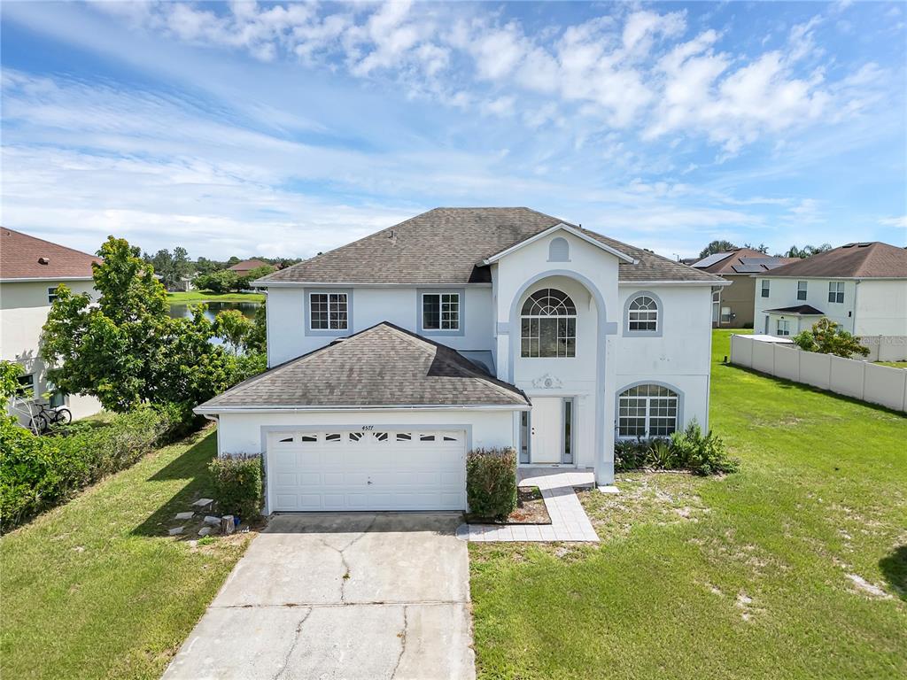 4577 Ficus Tree Road Kissimmee, FL 34758 - Photo 1 of 1 a front view of a house with a yard and garage