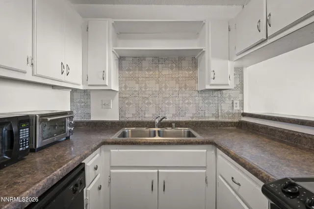 a kitchen with granite countertop a sink and a stove