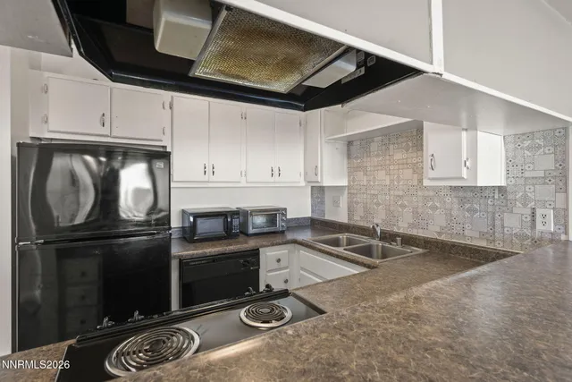 a kitchen with granite countertop a sink stainless steel appliances and cabinets