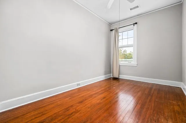 a view of an empty room with wooden floor