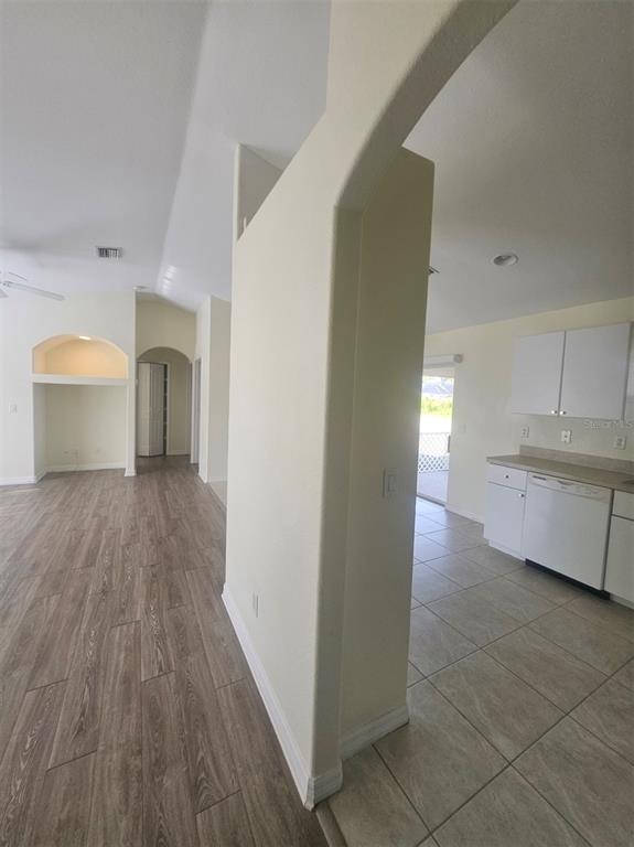 7450 Blutter Road North Port, FL 34291 - Photo 12 of 34 a view of a hallway to an empty room with wooden floor and a kitchen