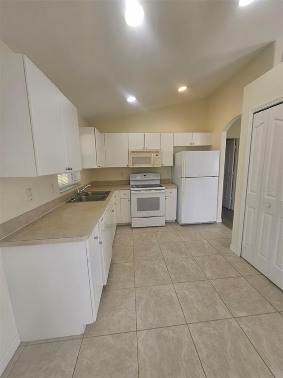 7450 Blutter Road North Port, FL 34291 - Photo 17 of 34 a kitchen with a sink a refrigerator and cabinets