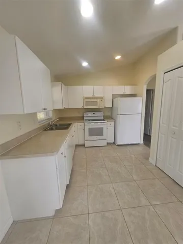 a kitchen with a sink a refrigerator and cabinets