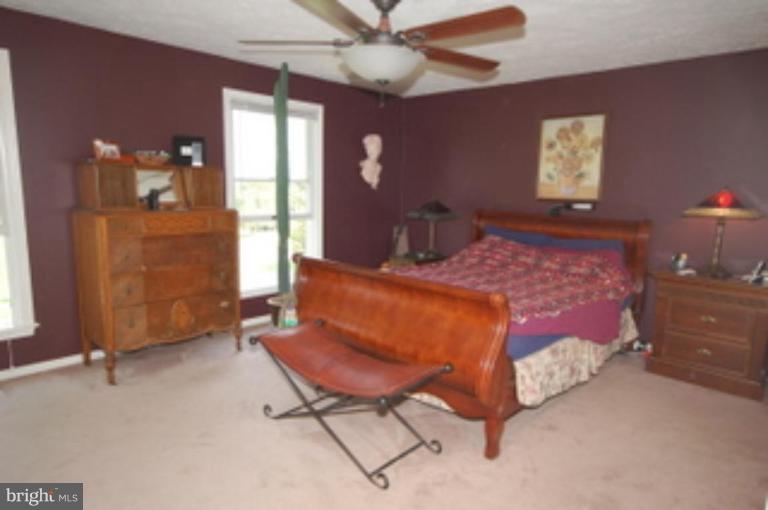 14143 Taylorstown Road Leesburg, VA 20176 - Photo 15 of 15 a bedroom with a bed and a chandelier