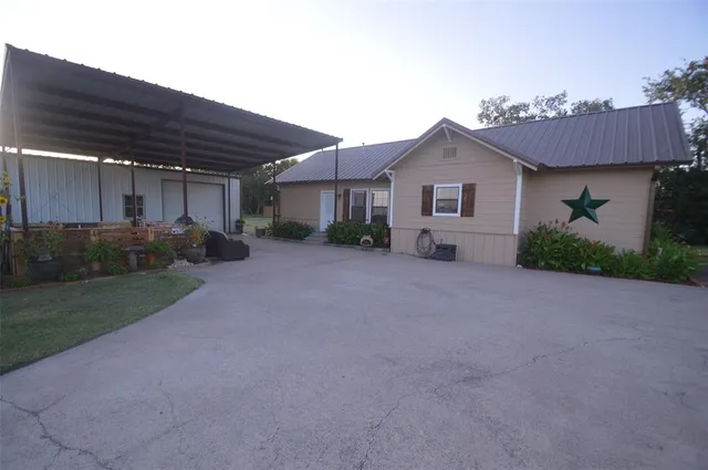 a view of a house with a yard and potted plants