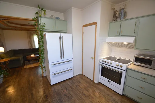 a kitchen with a wooden floor and a stove top oven