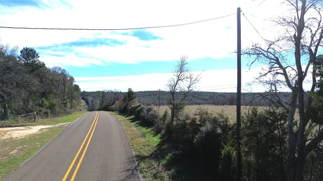 a view of a dry yard with wooden fence