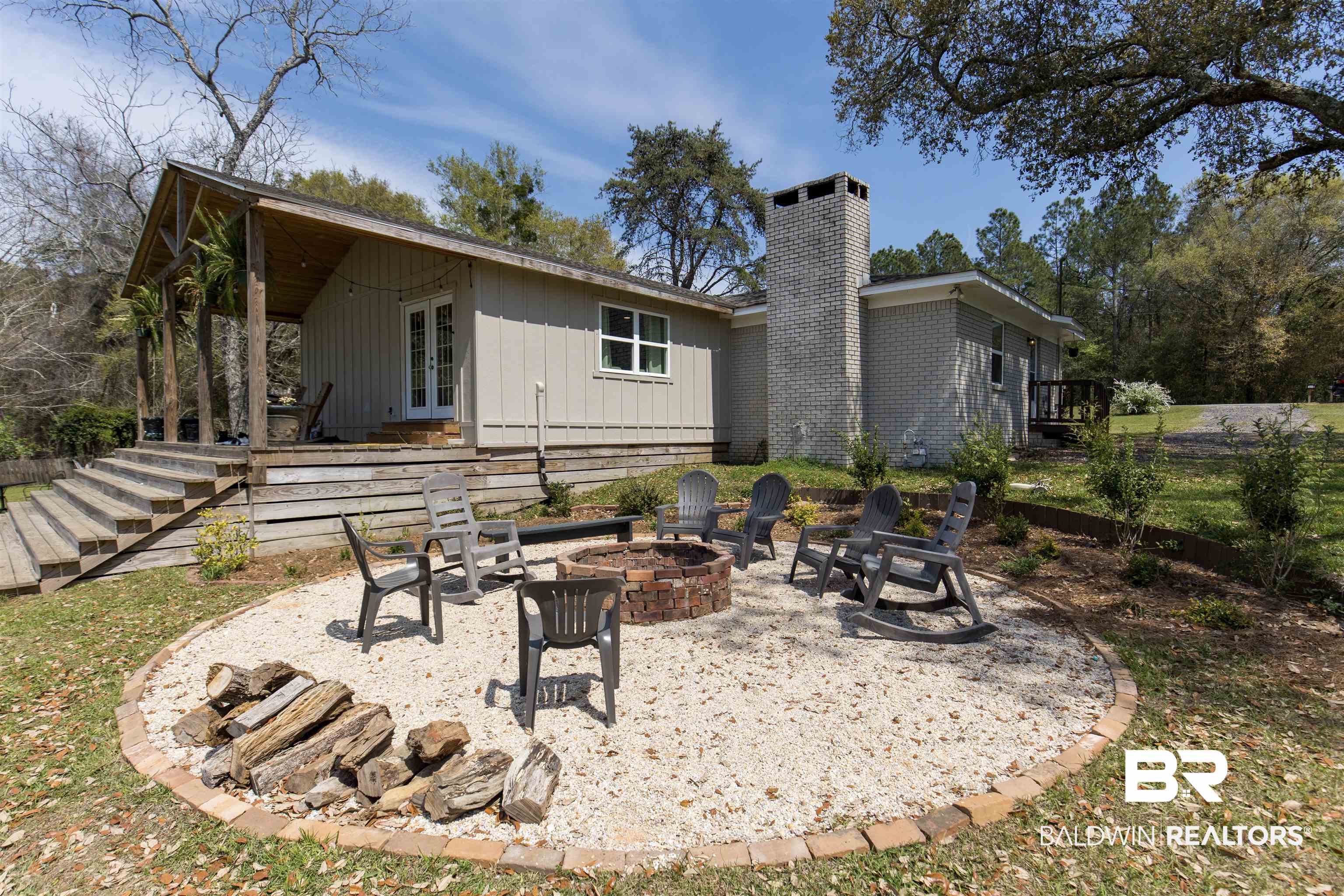 11100 Rhett McConnell Road Theodore, AL 36582 - Photo 22 of 47 Back of property with a patio area, a chimney, french doors, an outdoor fire pit, and board and batten siding