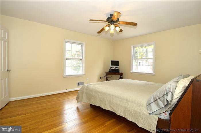 5402 Ridgefield Road Bethesda, MD 20816 - Photo 17 of 27 a bedroom with a bed and a chandelier