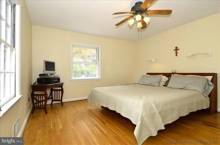 5402 Ridgefield Road Bethesda, MD 20816 - Photo 18 of 27 a bedroom with bed and a chandelier