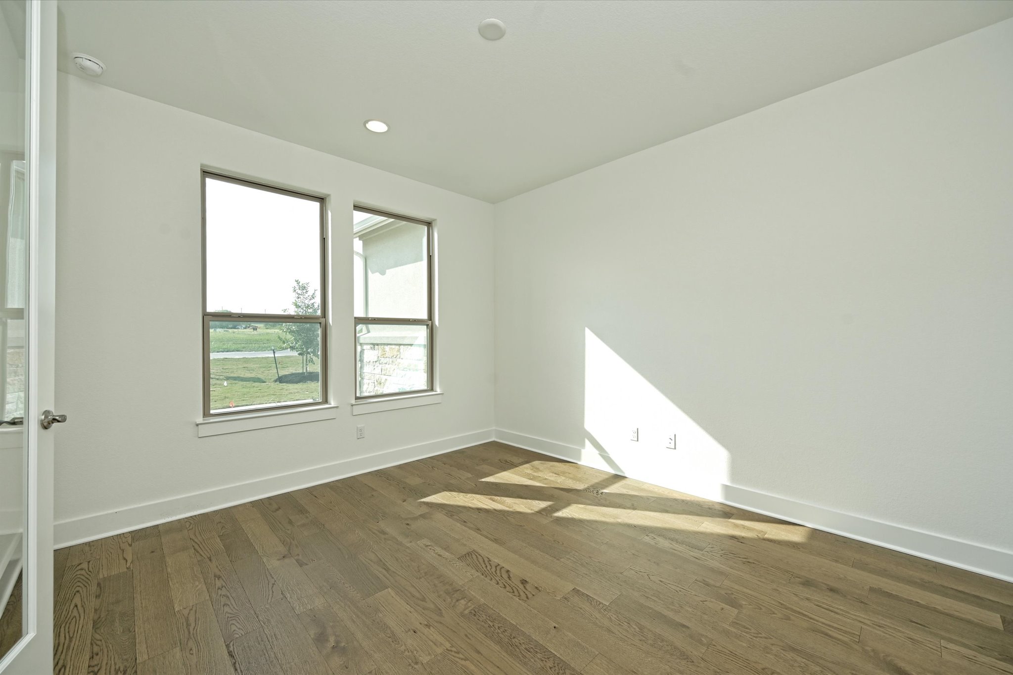 209 Scofield Avenue Georgetown, TX 78626 - Photo 15 of 33 an empty room with wooden floor and windows