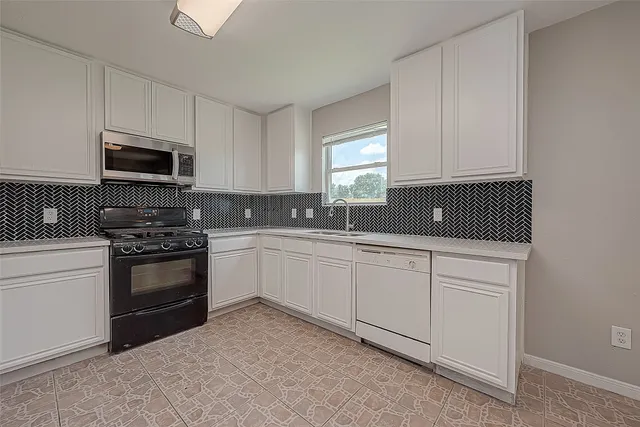 a kitchen with sink a microwave and cabinets