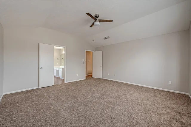 an empty room with a ceiling fan and windows