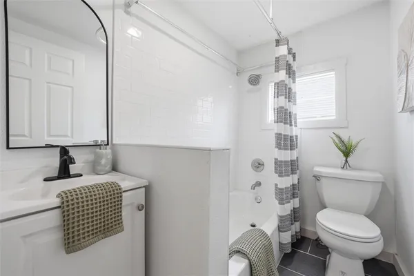 a bathroom with a granite countertop toilet sink and mirror