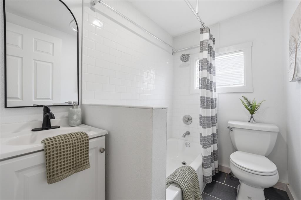 1116 Houston Street Waco, TX 76704 - Photo 13 of 16 a bathroom with a granite countertop toilet sink and mirror