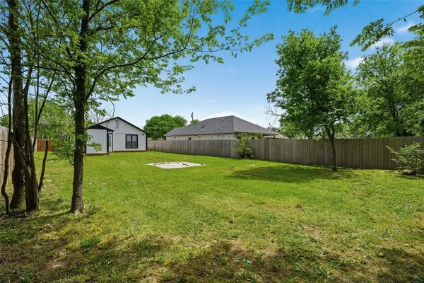 a view of a house with backyard and tree s