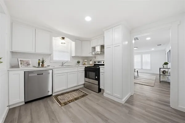 a kitchen with a refrigerator and white cabinets