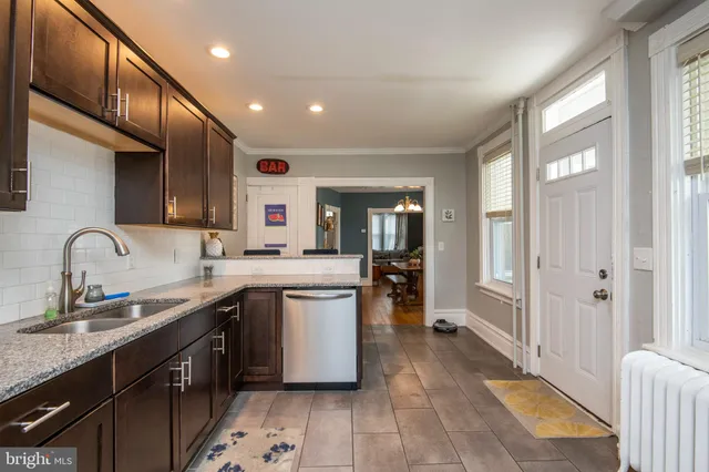 a kitchen with stainless steel appliances granite countertop a refrigerator a sink a stove and a refrigerator