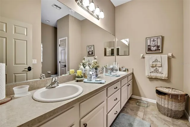 a spacious bathroom with a double vanity sink and a mirror
