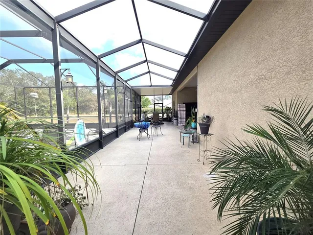a living room with patio furniture and a floor to ceiling window