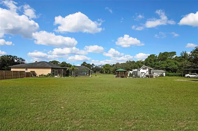 a aerial view of a house with a yard table and chairs