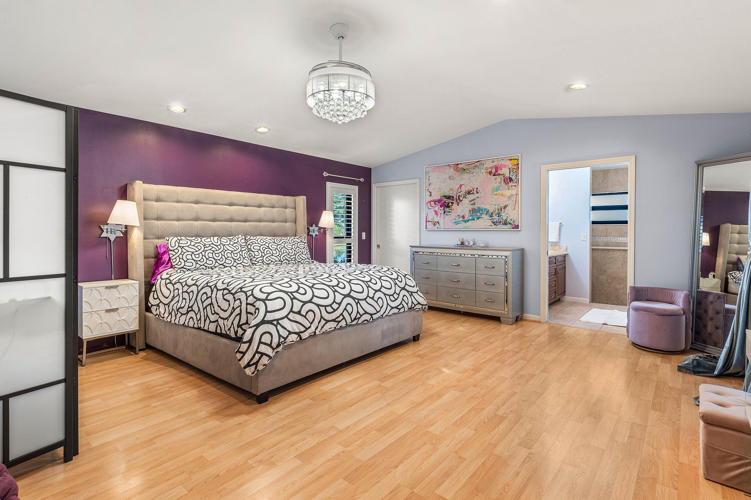 10174 Crosswind Road Boca Raton, FL 33498 - Photo 18 of 45 a bedroom with a bed and a chandelier